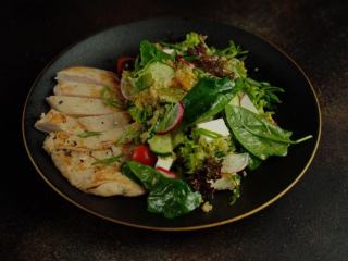 Une horloge posée près d'une assiette composée, qui rappelle les horaires du 16/8